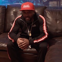 a man sitting on a couch wearing a red hat