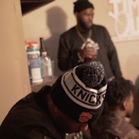 a group of people sitting in a room with a hat on