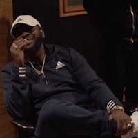 a man sitting in a chair and smoking a cigarette