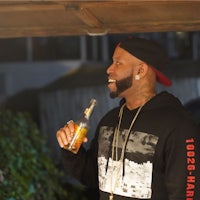 a man holding a bottle of beer and smiling