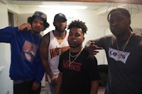 four men standing next to each other in a room