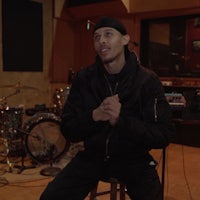a man sitting on a stool in a recording studio