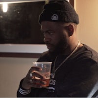 a man with a beard holding a cup of beer