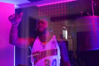 a man standing in front of a microphone in a recording studio