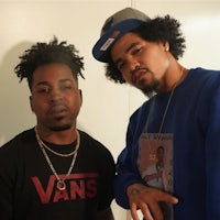 two men standing next to each other in a room