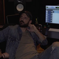 a man sitting in front of a computer in a recording studio